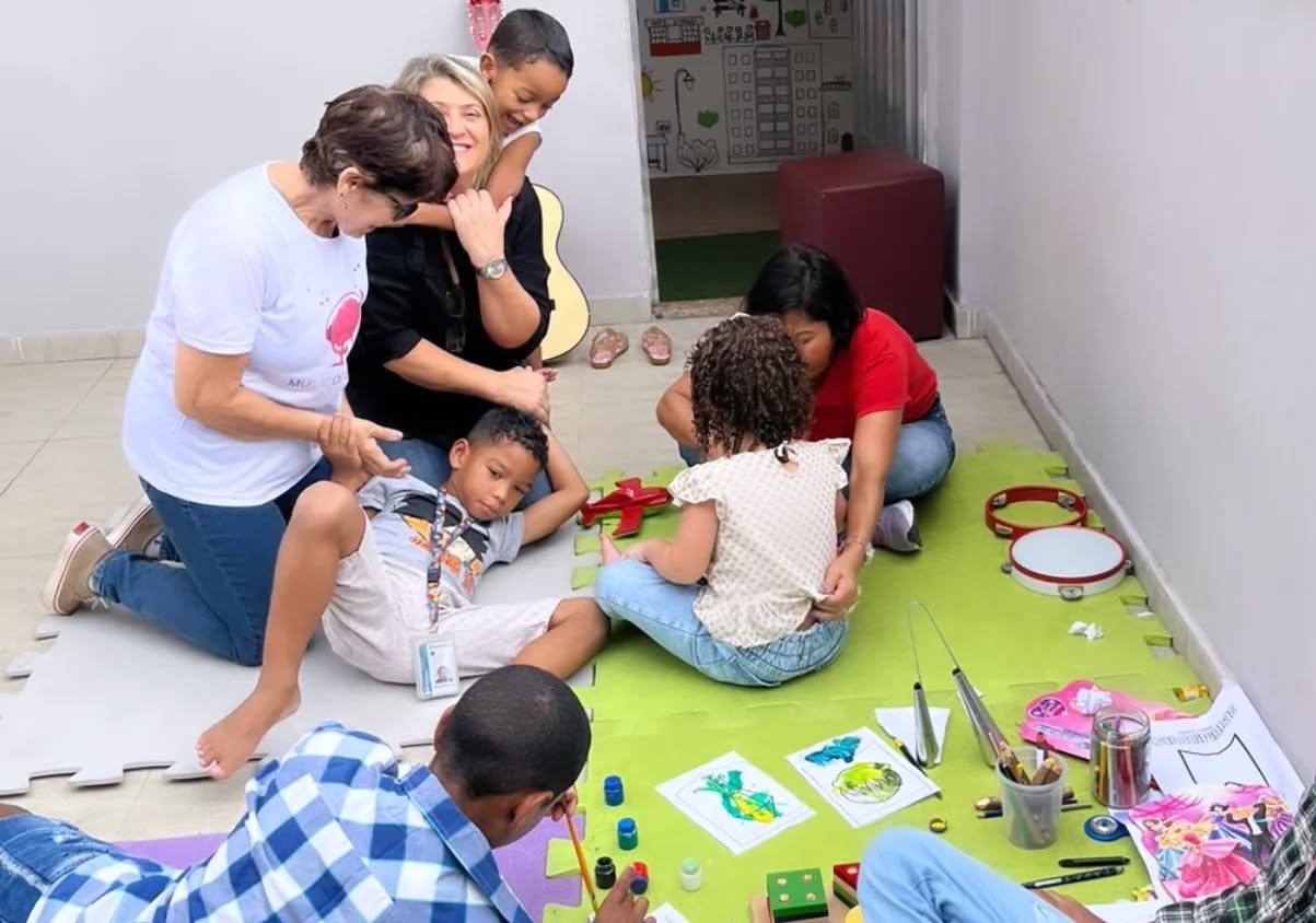 A psicopedagoga Rosane Araújo é abraçada por aluno durante atividade na clínica em que trabalha: a ausência de diagnósticos precoces ainda provoca um apagamento cruel (Foto: Reprodução / Facebook)