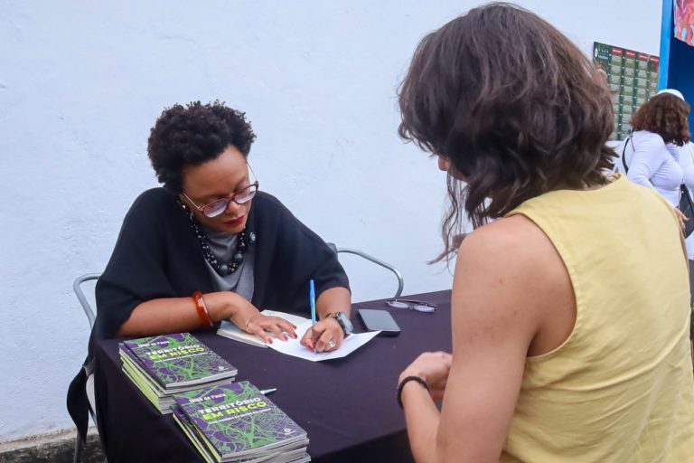Tainá de Paula autografa seu livro 'Território de Risco', durante o pré-lançamento na Flip: "O calor extremo mata de um jeito diferente: devagar, todos os dias, sem aparecer no boletim de óbitos como morte por calor" (Foto: Wagner da Silva / Divulgação)