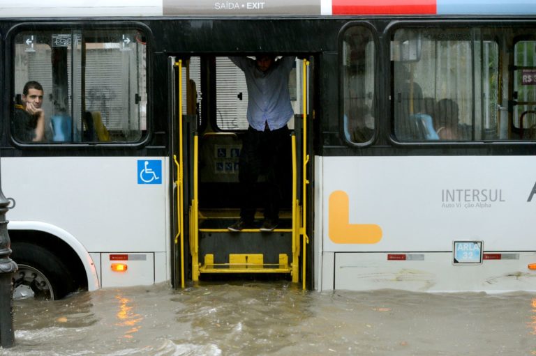 Passageiros ilhados em ônibus durante temporal no Rio: milhões de brasileiros dependem de sistemas de transporte altamente vulneráveis a eventos extremos do clima (Foto: Fernando Frazão / Agência Brasil)