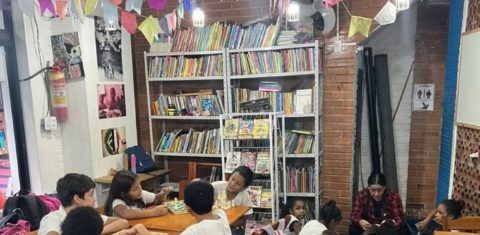Crianças na Garagem de Livros, na Rocinha: desafio de fazer a literatura parte da infância (Foto: Garagem dos Livros / Facebook / Reprodução)