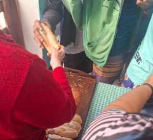 Homem em situação de rua recebendo pão de uma voluntária da Igreja de Santo Antônio. Foto João Gabriel Corrêa