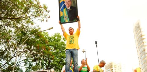 Flávio Bolsonaro com a foto de Jair em Goiânia: volta da extrema-direita ao poder no Brasil ameaça a Amazônia e o clima no planeta (Foto: Charles Vieira / Divulgação)